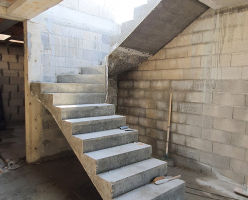 Réalisation d'un escalier béton lors de la construction d'une maison contemporaine par AIT Bâtiment